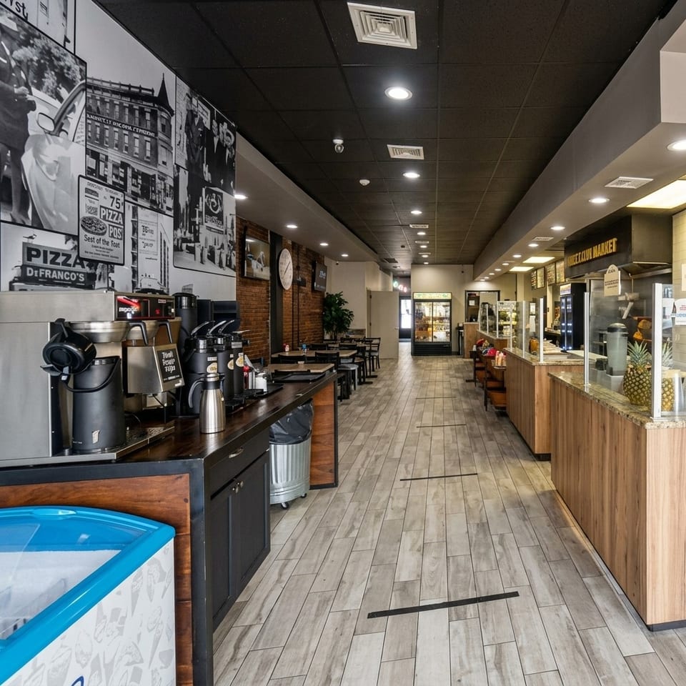 Bright De Franco’s pizzeria interior with vintage wall murals, counter seating, self-serve drinks, and ordering counter.